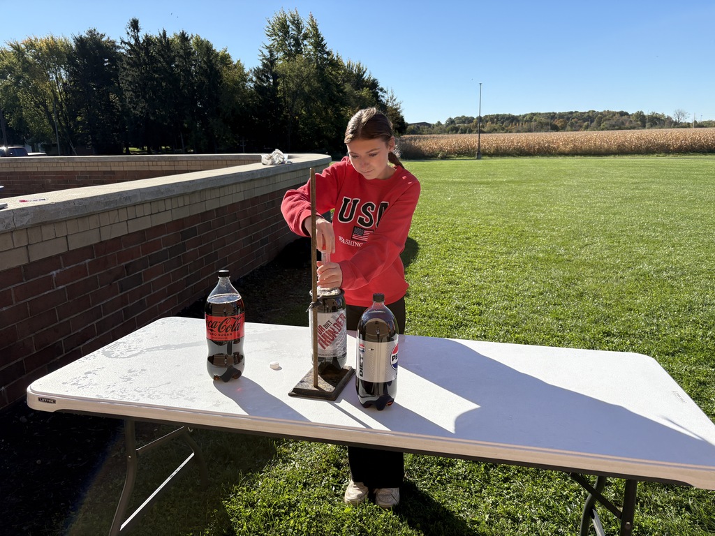 Student at a table with 2-liter bottles of soda