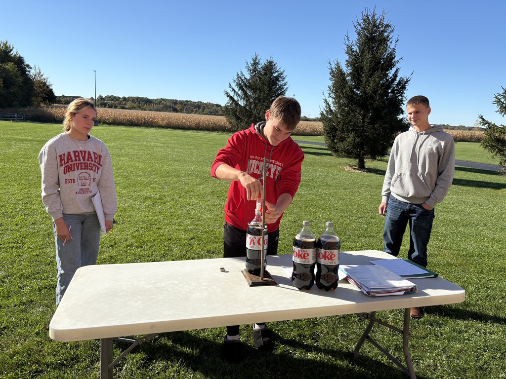 Student at a table with 2-liter bottles of soda