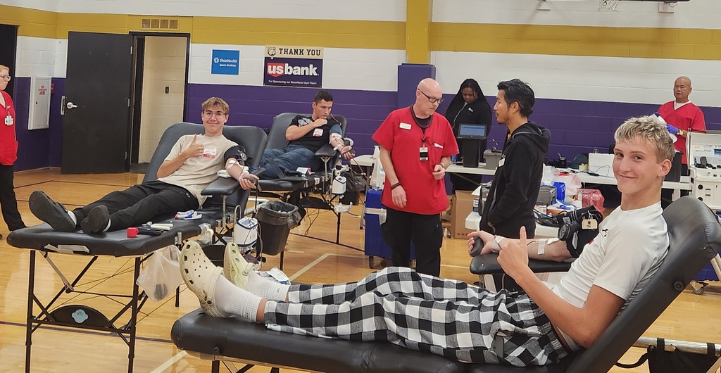 Student reclining giving blood giving a thumbs up 