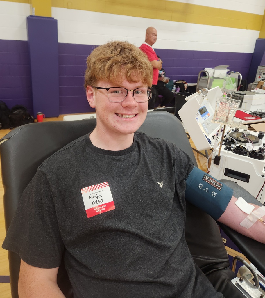 Student smiling with glasses and a blood pressure cuff on his arm