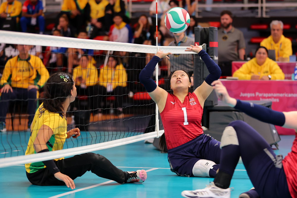 Volleyball player setting the ball over a net