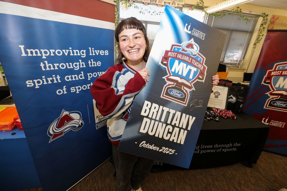 Smiling woman holding a most valuble teacher award