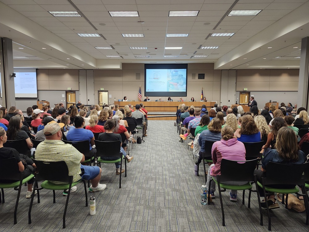 Families, students and staff sitting in the crowd of the Board of Education meeting