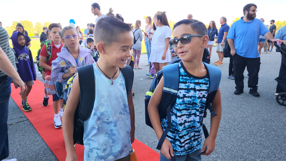 Two students smiling and walking into school