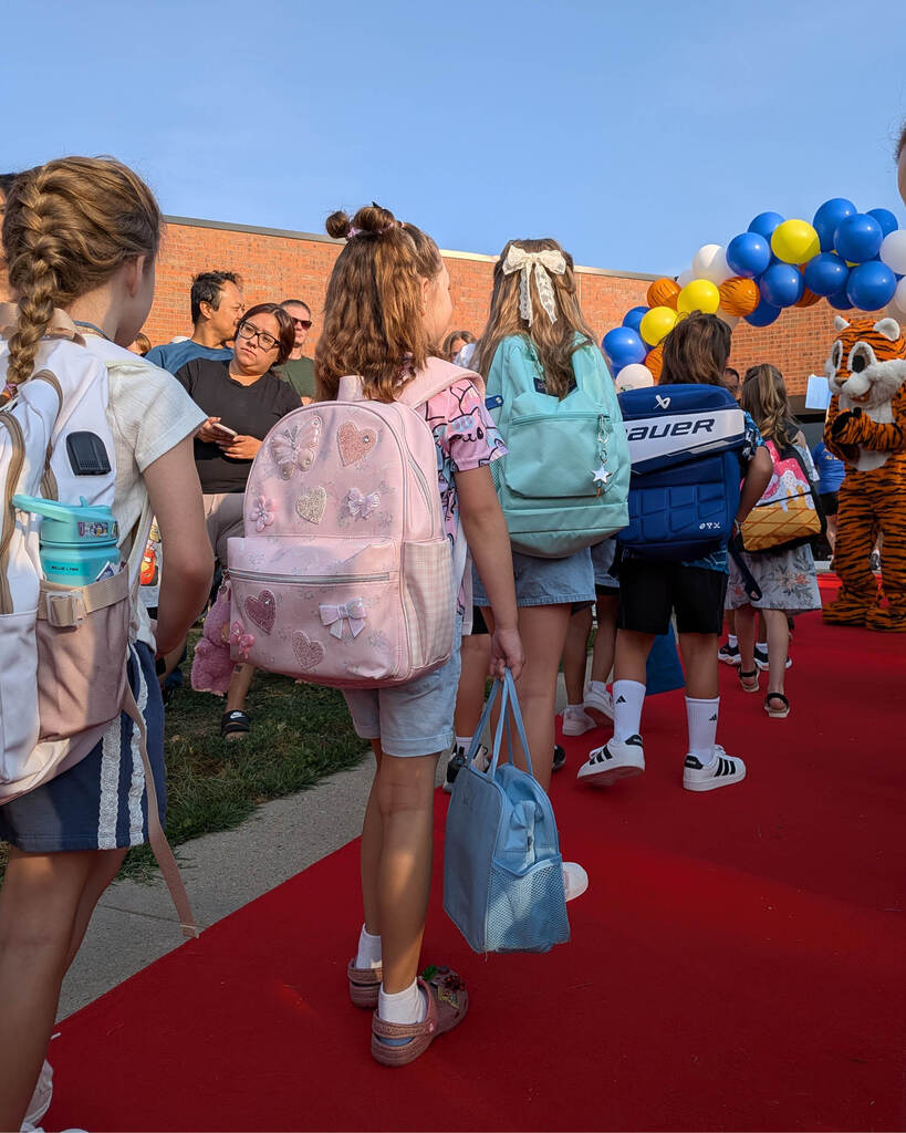 Students walking the red carpet in a parade