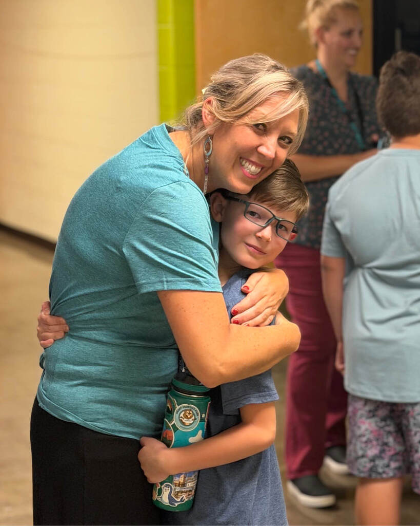 Teacher giving student a hug