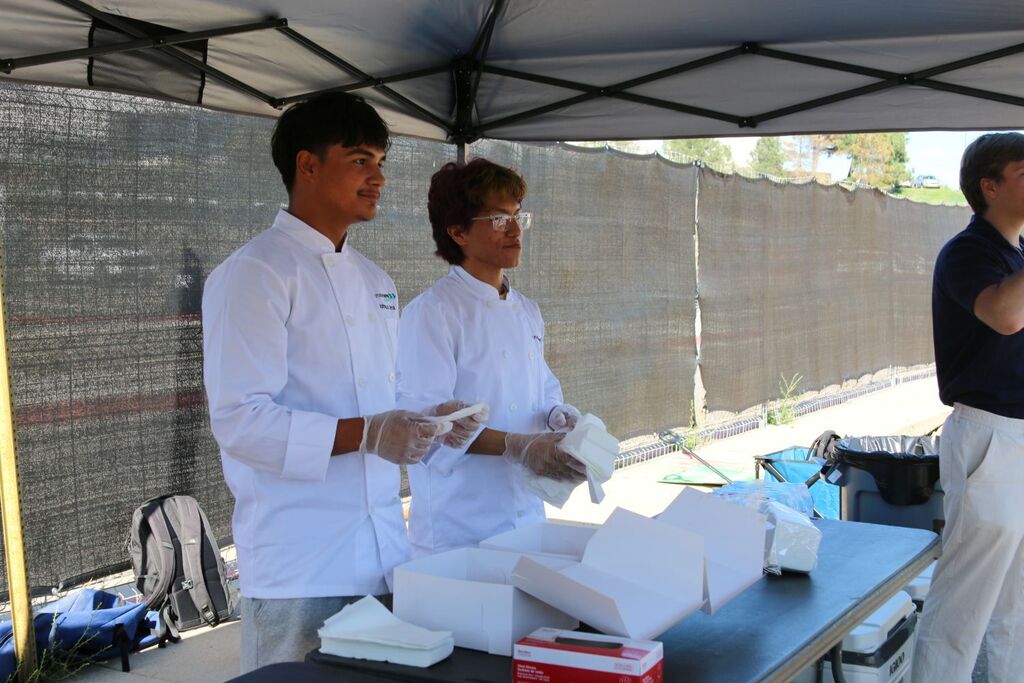Two cooking students handing out cookies