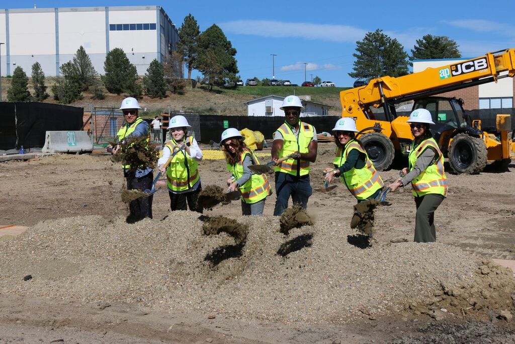 Six people shoveling dirt for the groundbreaking ceremony