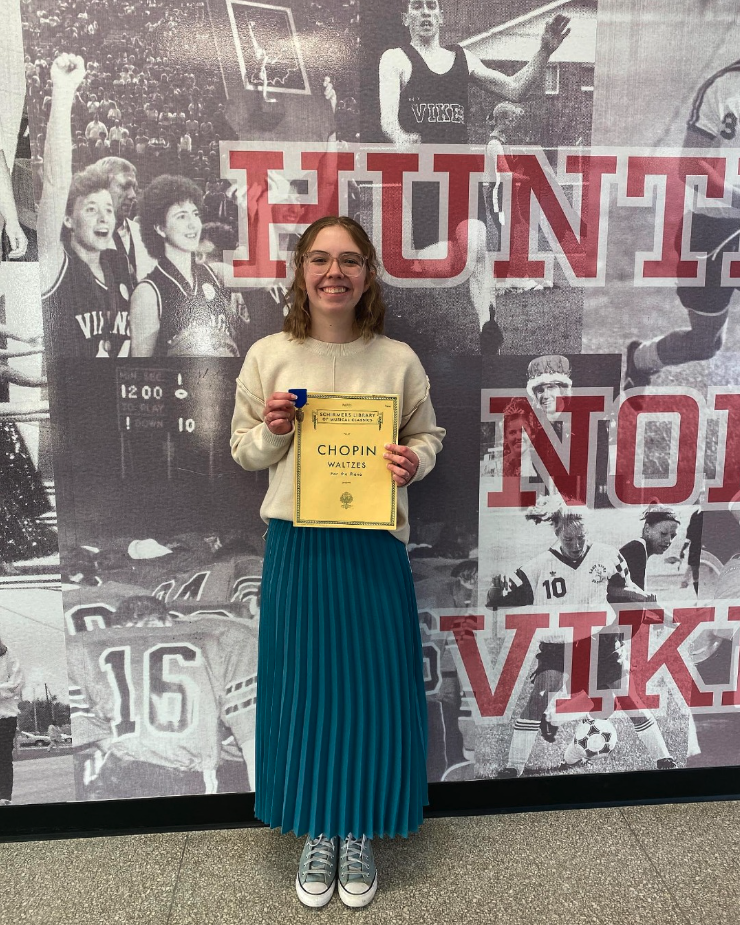 Student  holding ISSMA certificate and medal.