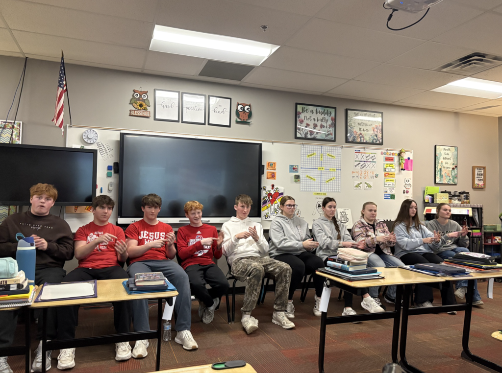 Students sitting at the front of the classroom practicing ASL Songs