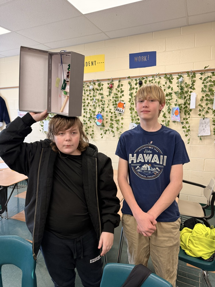 Two students holding their vertical farm model.