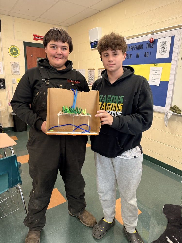 Two students holding their vertical farm model.