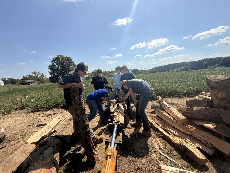 Students stacking fire wood.