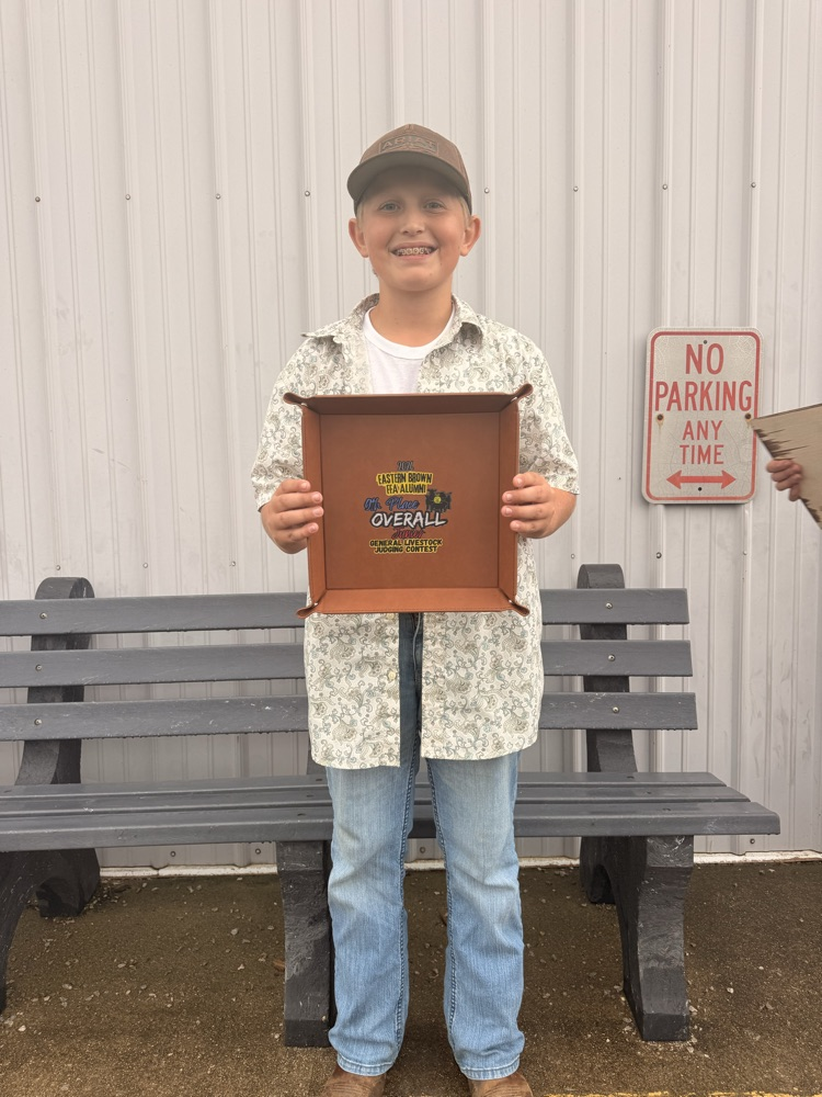 A young boy holding an award.