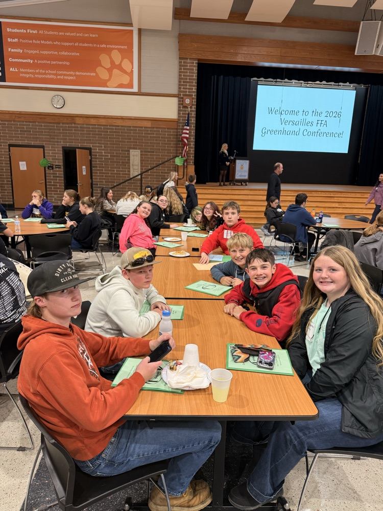Students posing for a picture at a lunch table.