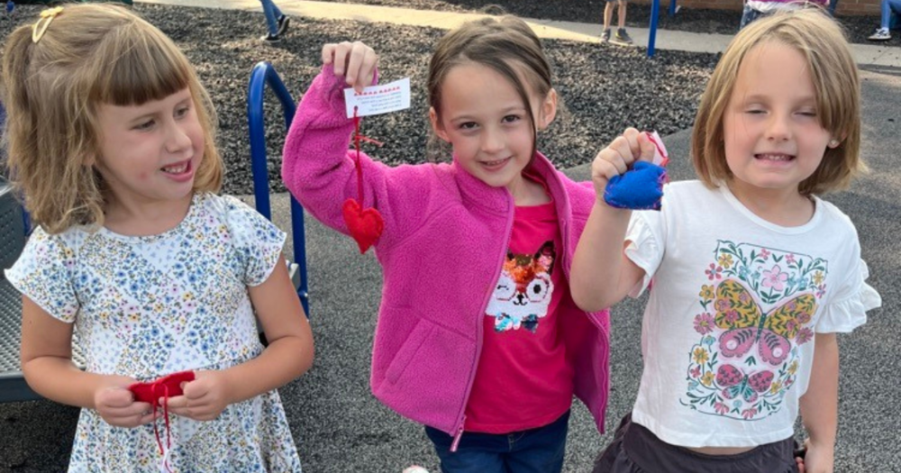 Student show off the friendship pocket hearts others sewed for them