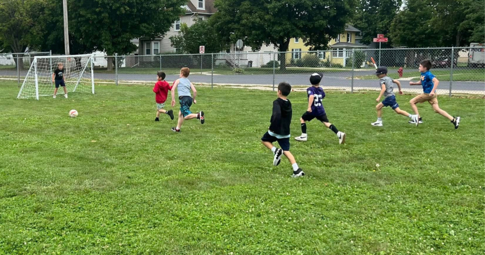 Elementary boys trying to score soccer goal
