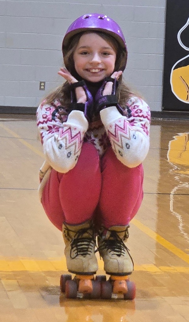 female student scrunch down roller skating and smiling!