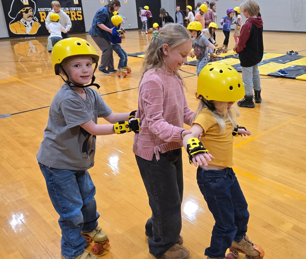 three students in a line, two have helmets roller skating