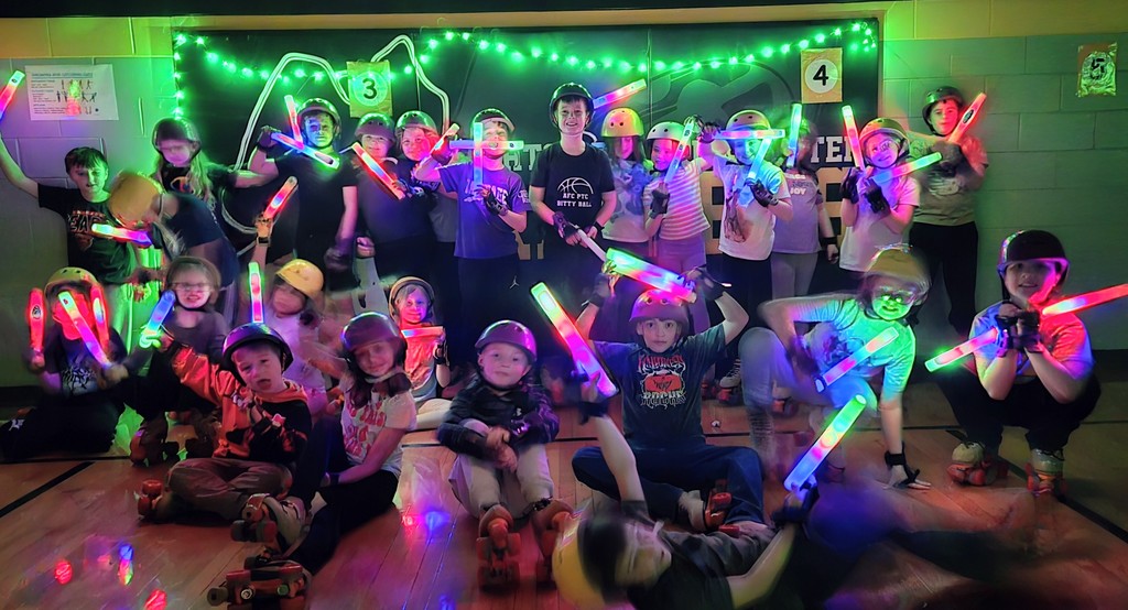 Large group photo with lights off and glow sticks with lights off. Students are smiling!