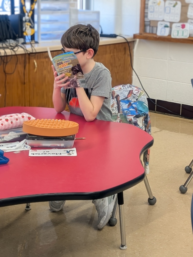male student reading at table