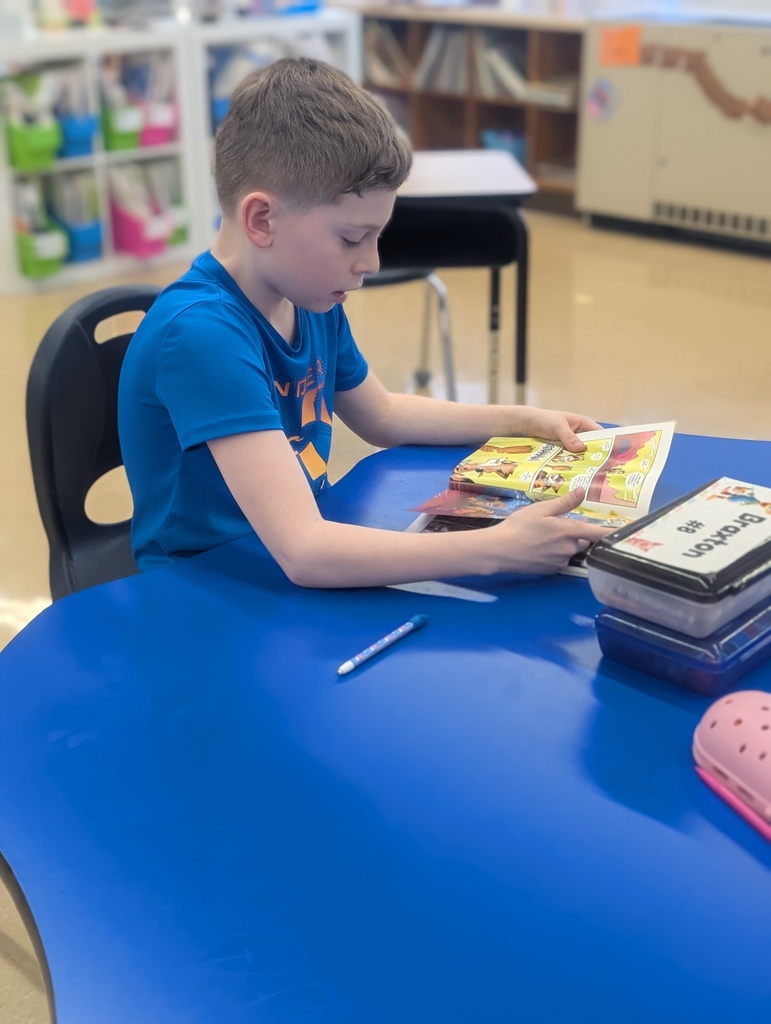 male student reading at a table