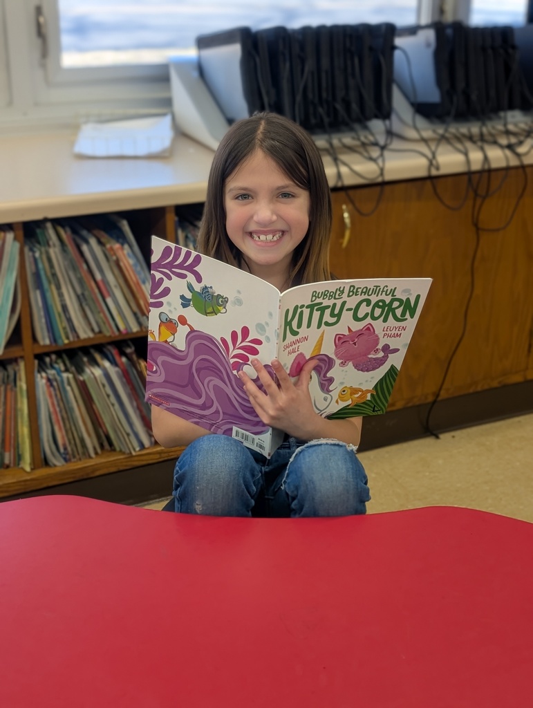 student posing and similing with her book