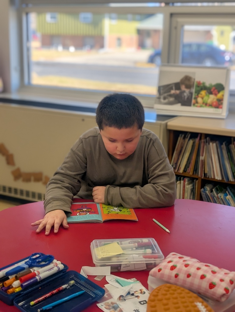 male student reading at a table