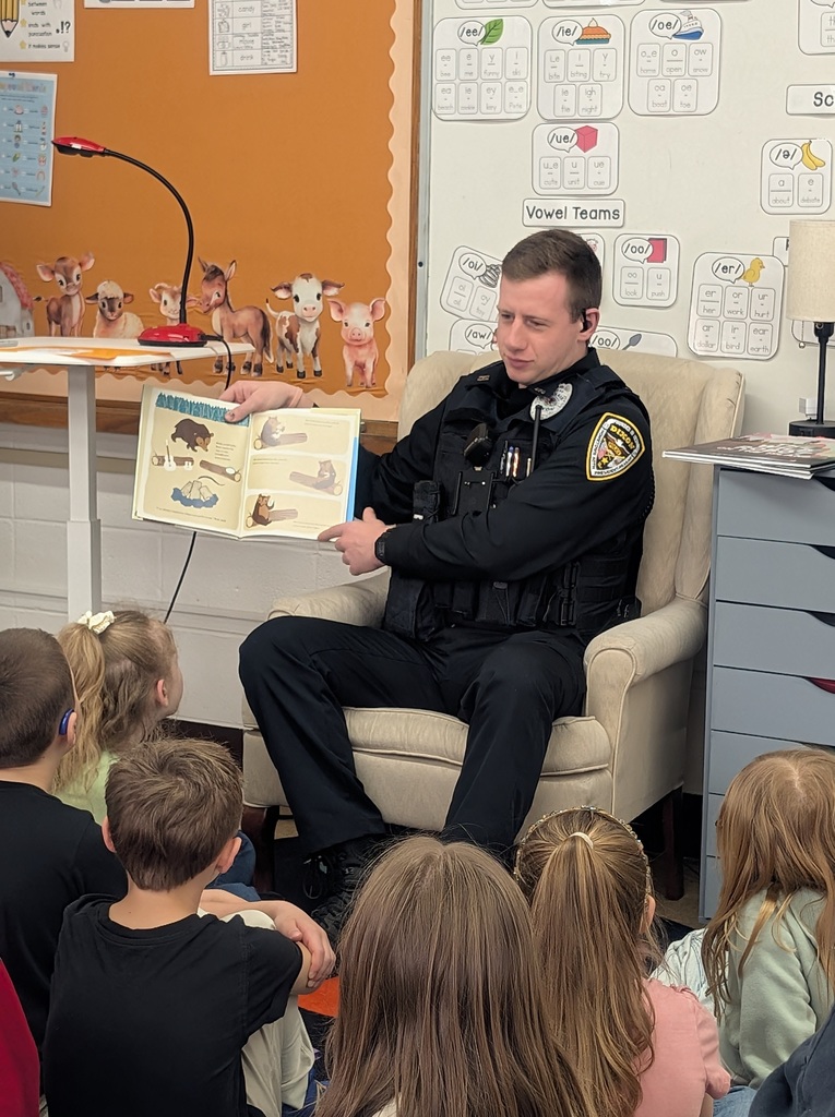 Officer in uniform reading to students