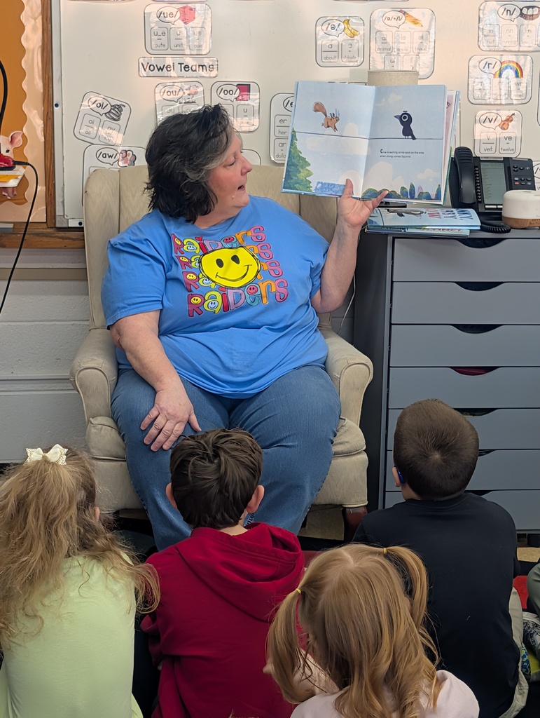 Female volunteer reading to students