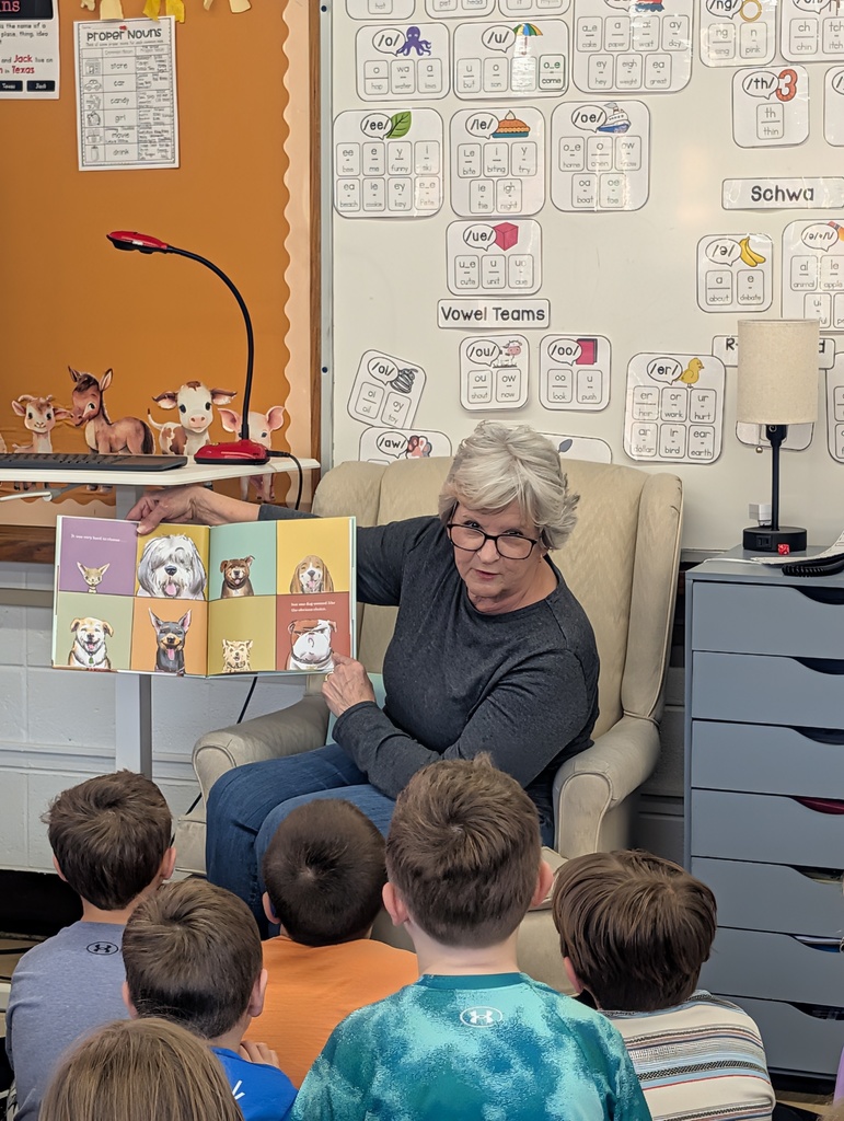 Older woman with glasses reading to students