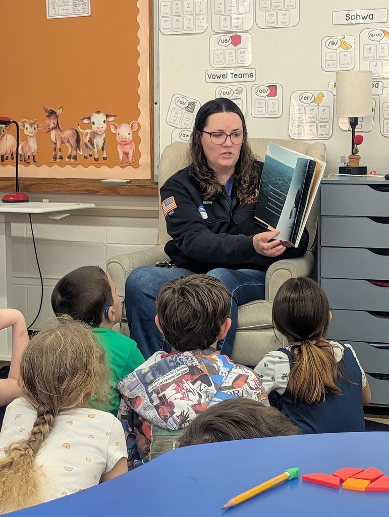 Female police officer reading to students