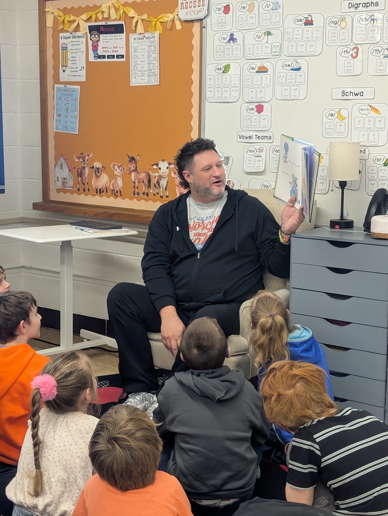 male volunteer reading to students