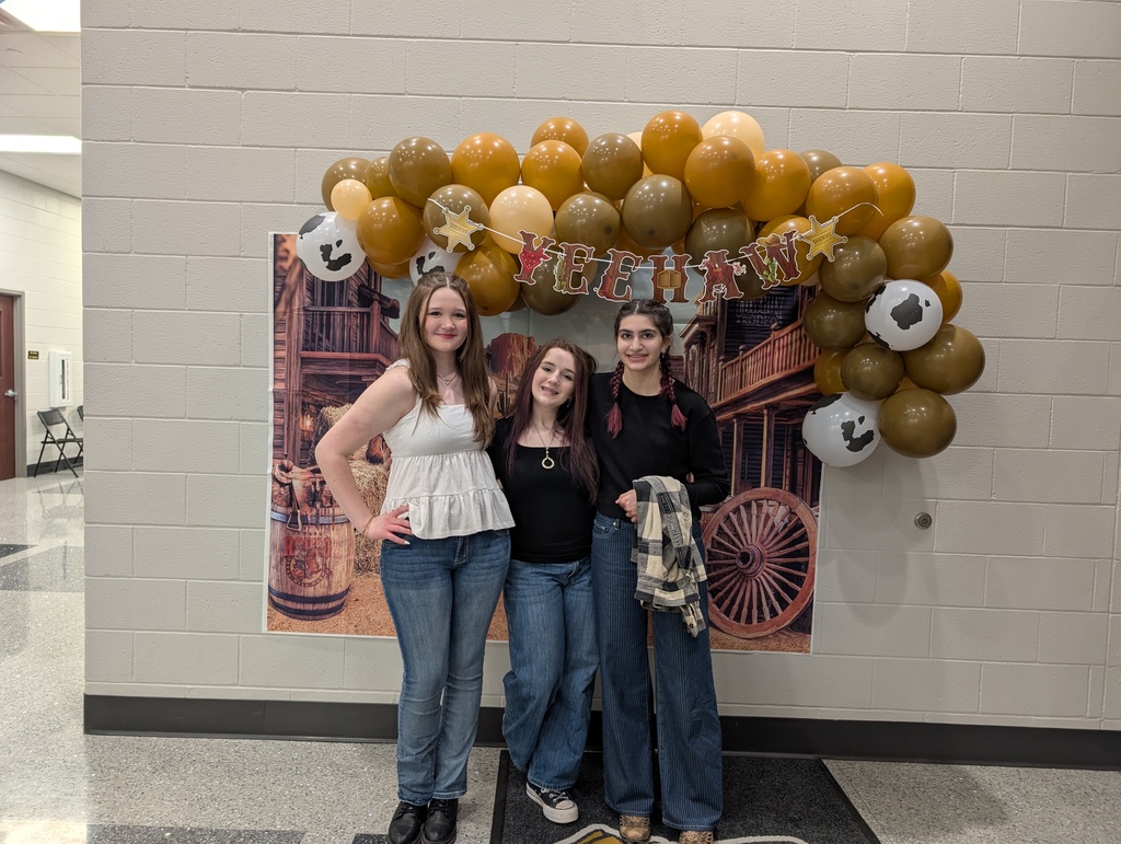 Three girls posing in front of country  balloon arch
