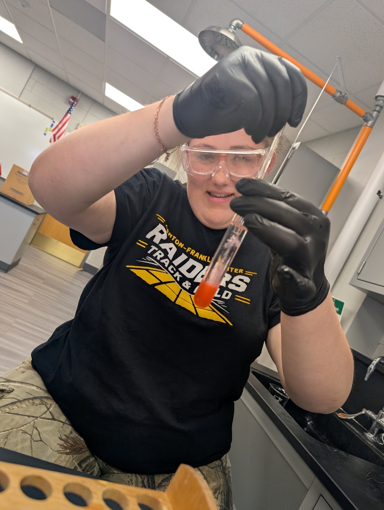female student looking at her test tub
