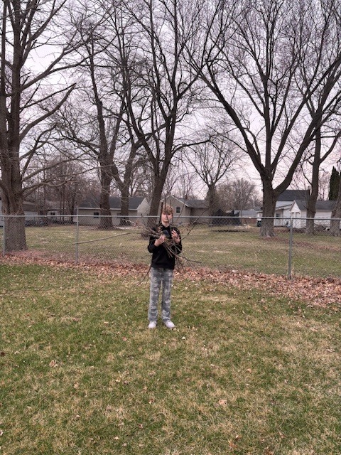 student holding a lot of sticks!