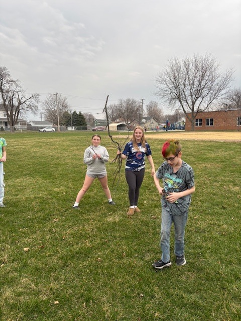 photo of students throughout the grass picking up sticks