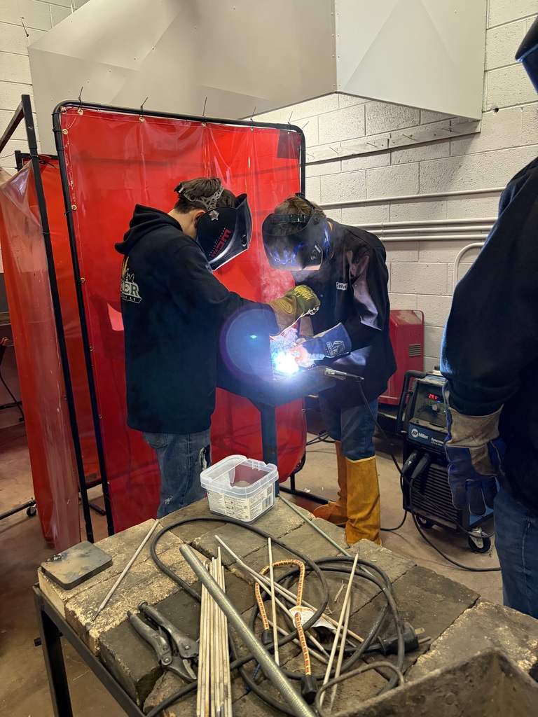 students in welding helmets learning to weld