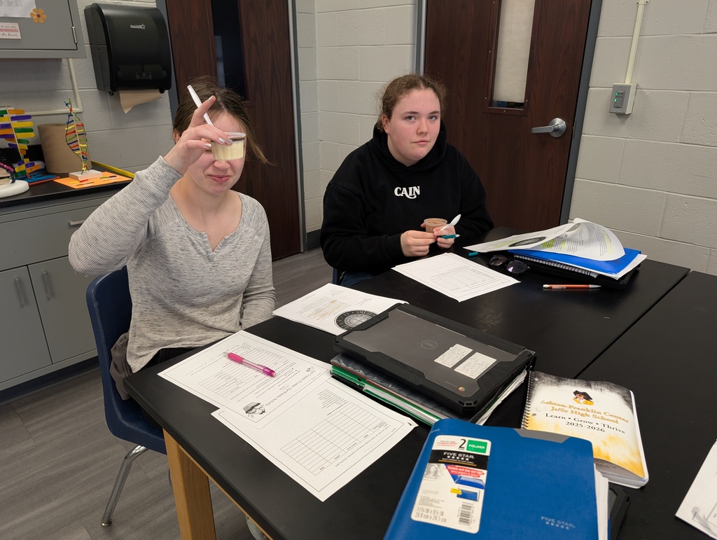 two female students with ice cream in their hands sitting at the science table