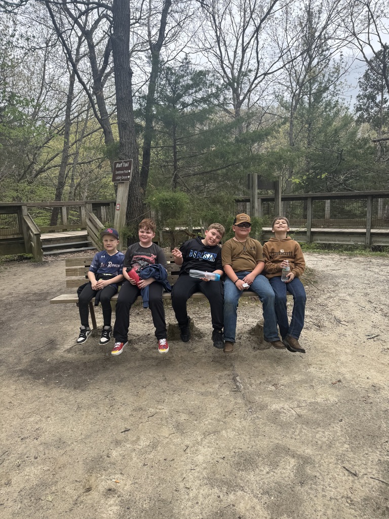 group of boys sitting on a park bench