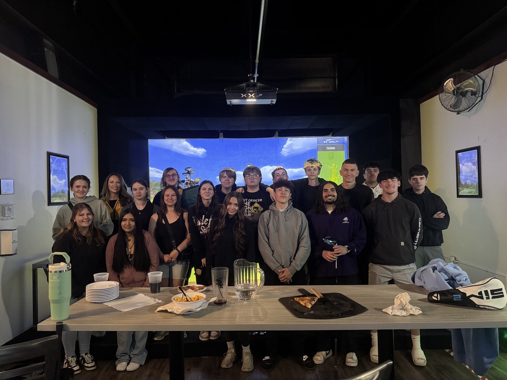 large group of high school students at golfx posing in front of screen.