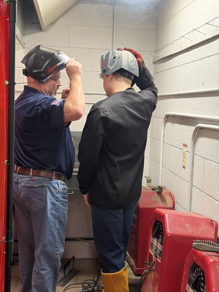 visitor working one on one with a student welding