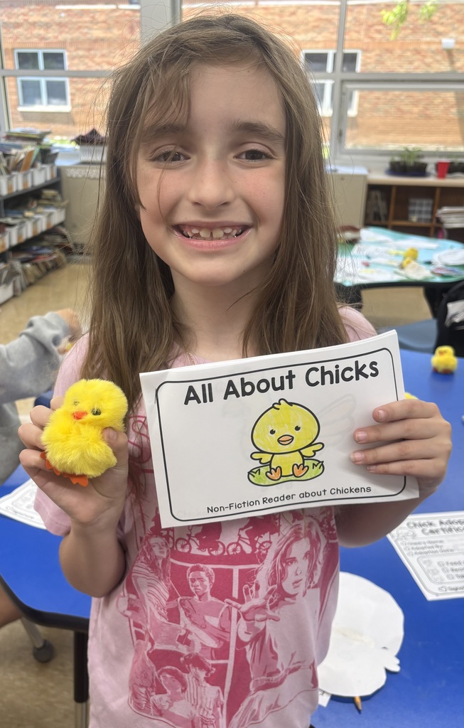 female student smiling holding chick adoption certificate with a plush chick