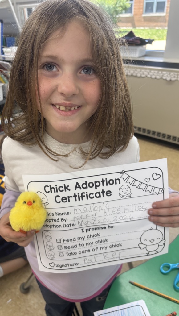 female student smiling holding chick adoption certificate with a plush chick