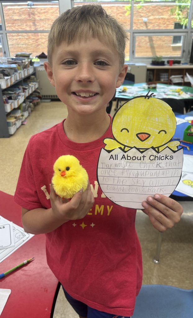 male student smiling holding chick adoption certificate with a plush chick