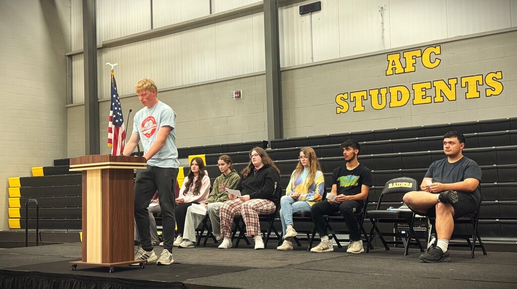 students on stage. one student on the podum 