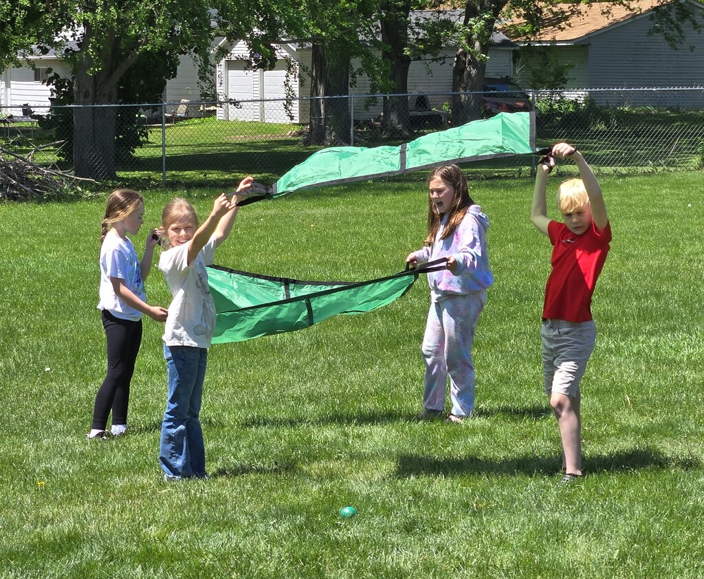 4 students playing in the grass