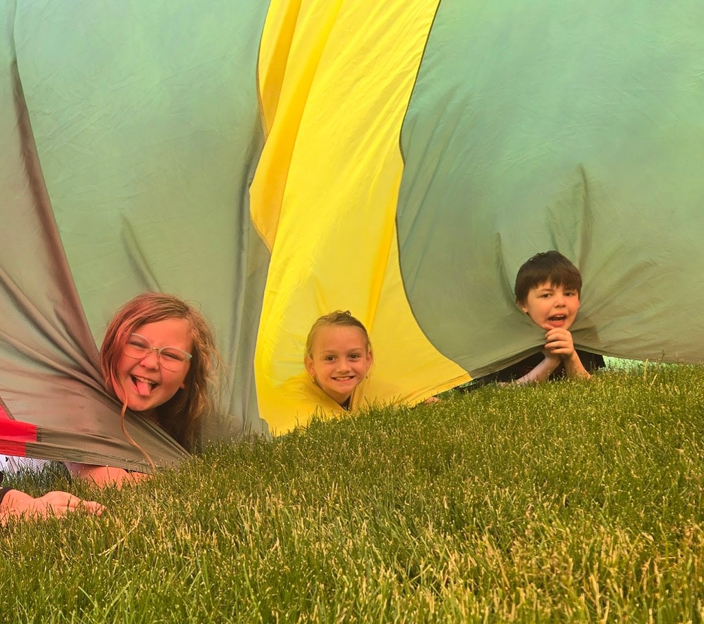 students playing parachute outside under the parachute