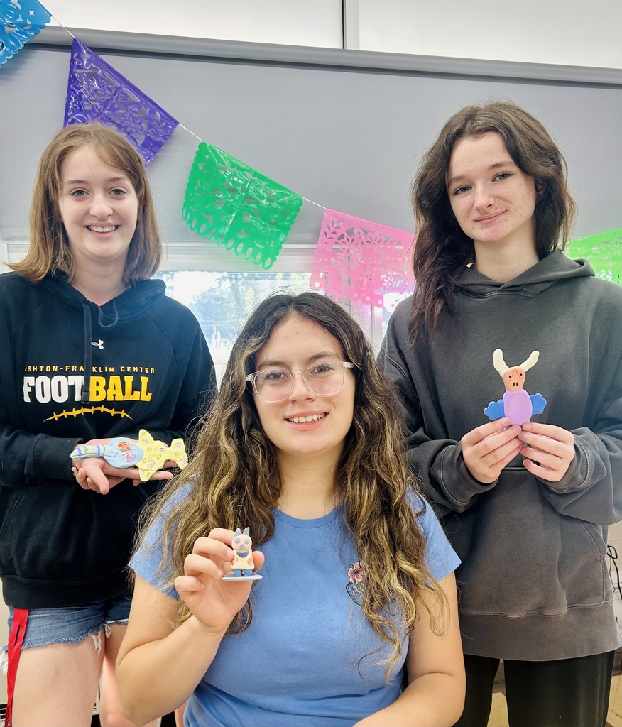 three students holding  Alebrijes