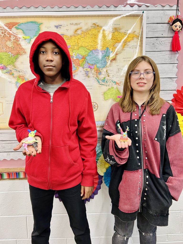 two students holding  Alebrijes